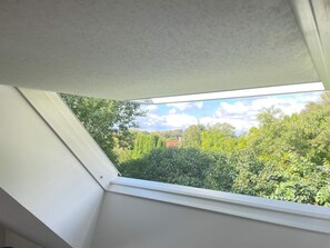A skylight window with a view of dense greenery and a distant building. - 4 Star Holiday Home in Oxie (Oxie)