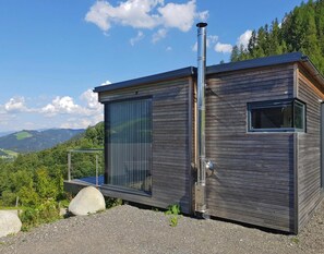 A modern cabin with a large window and a chimney, set against a mountainous backdrop. - 4 Star Holiday Home in Gaal im Murtal (Gaal)