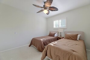 A bedroom with two beds, a ceiling fan, a window with blinds, and a carpeted floor. - 1 Mi to Dtwn Downey + Fenced Yard! (Downey)