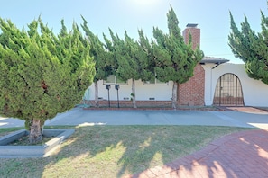 A residential building with a brick facade, a gated entrance, and a well-maintained lawn. - 1 Mi to Dtwn Downey + Fenced Yard! (Downey)