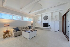 A modern living room with a sectional sofa, a coffee table, a floor lamp, a fireplace, and built-in storage cabinets. - 1 Mi to Dtwn Downey + Fenced Yard! (Downey)