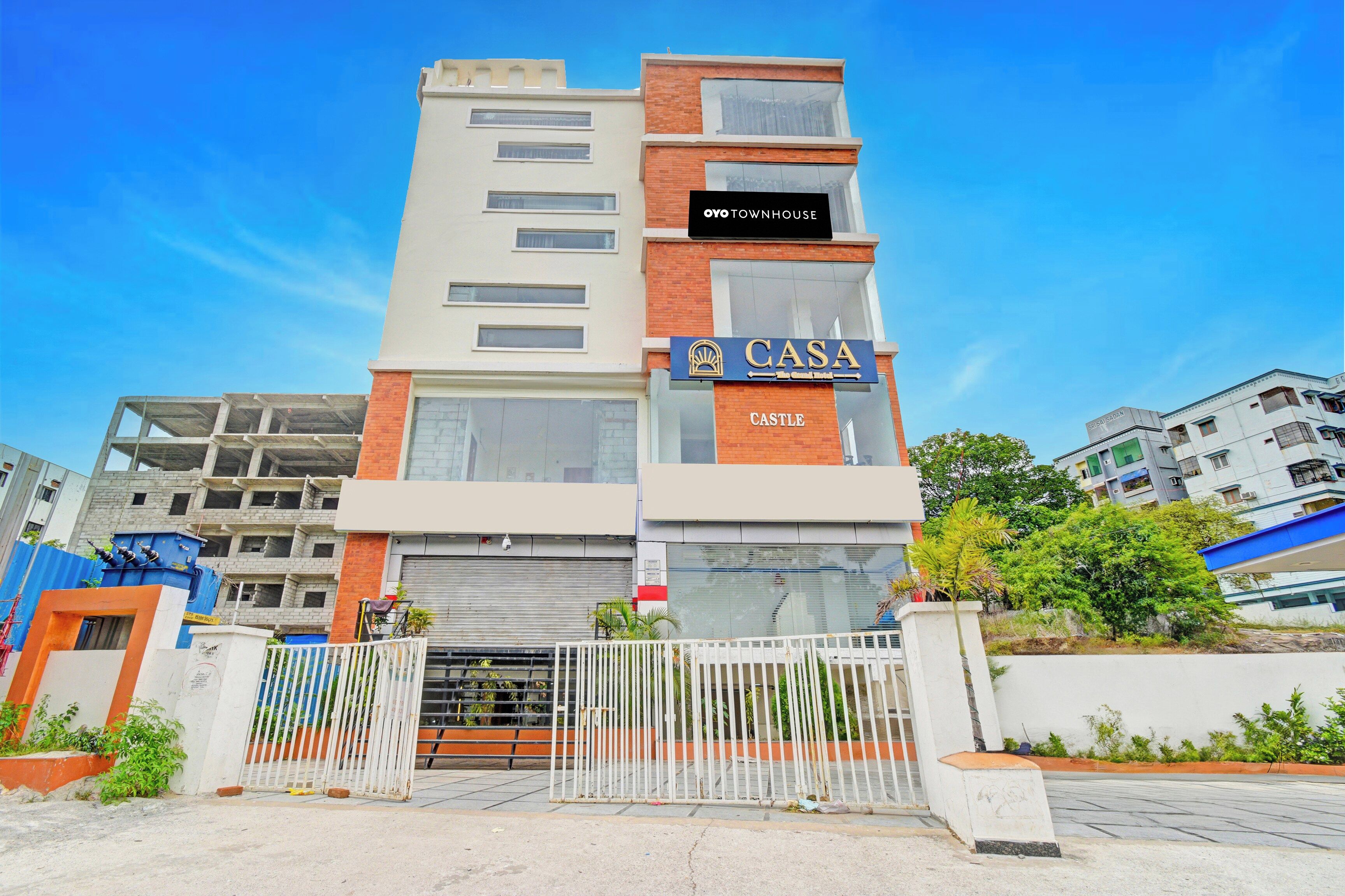 Un edificio de varios pisos con un letrero que indica 'CASA' y 'OYO TOWNHOUSE', señalando que se trata de un hotel.
