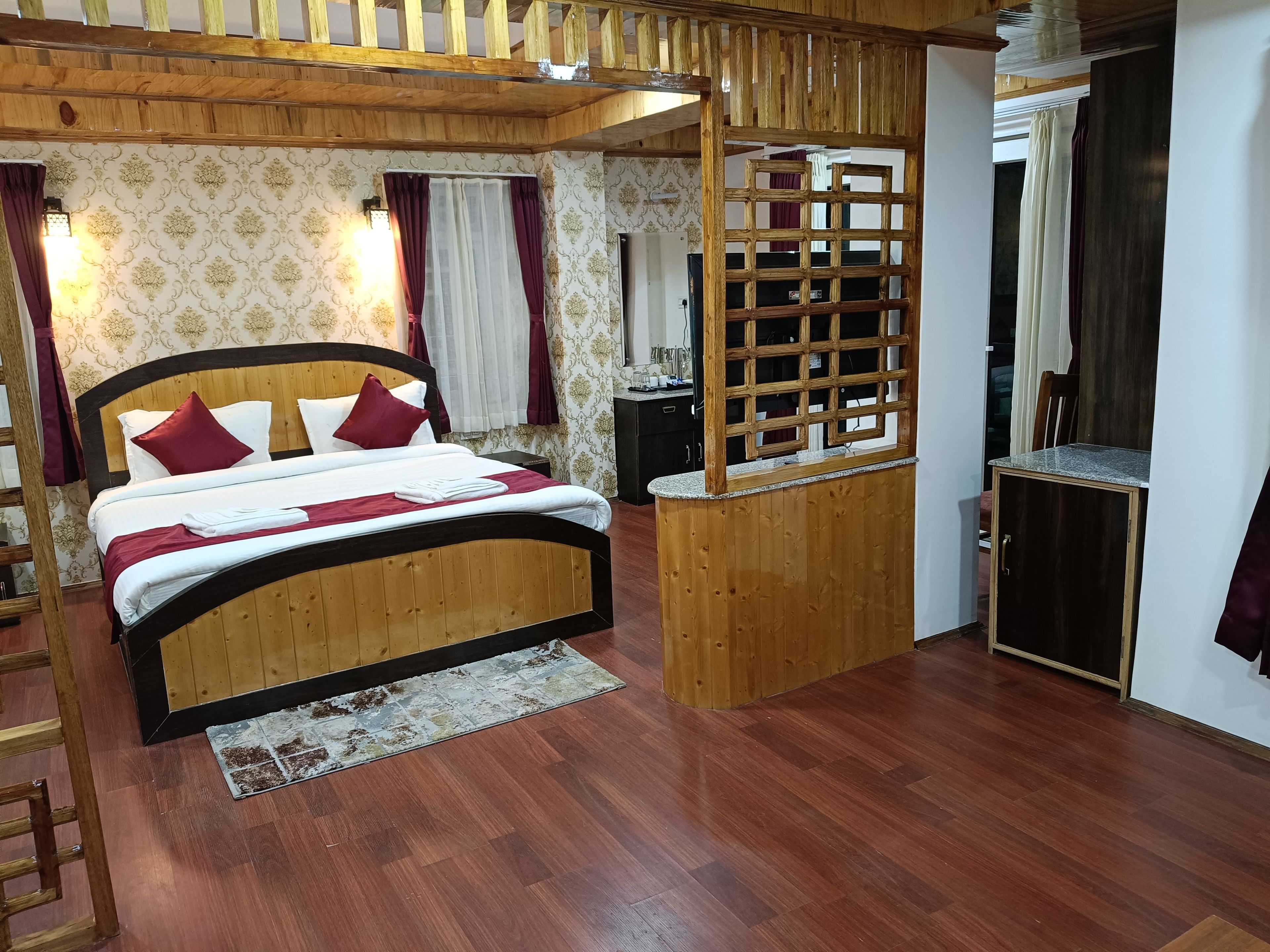 Una cama con estructura de madera y cabecera, un escritorio pequeño de madera y un espejo.