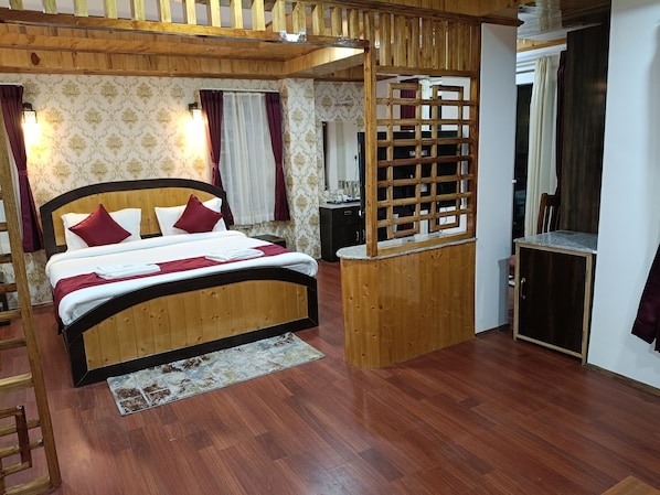 A wooden-framed bed with a headboard, a small wooden desk, and a mirror.