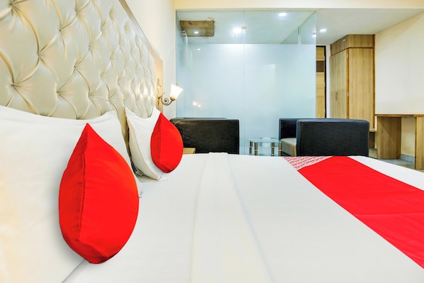 Una habitación de hotel con una cama grande, un escritorio y una silla.