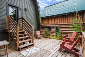 A wooden deck with outdoor seating and a staircase leading to a building. - Adventure and Ski All Day, Sip, Soak, and Relax at Night in the Heart of Government Camp (Government Camp)