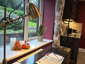 A desk with a lamp, a potted plant, a candle, and a notebook with a map.