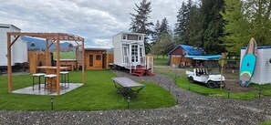 Ein Freizeitbereich mit einer Holzpergola, einem kleinen Tisch und einer Sitzgruppe.