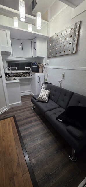 A modern kitchen with white cabinetry, a built-in oven, and a countertop with a coffee maker.