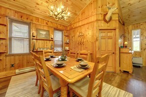 A wooden interior with a dining table set for four, surrounded by chairs. - Old Forge Winter Escape: Snowmobile & Ski! (Old Forge)