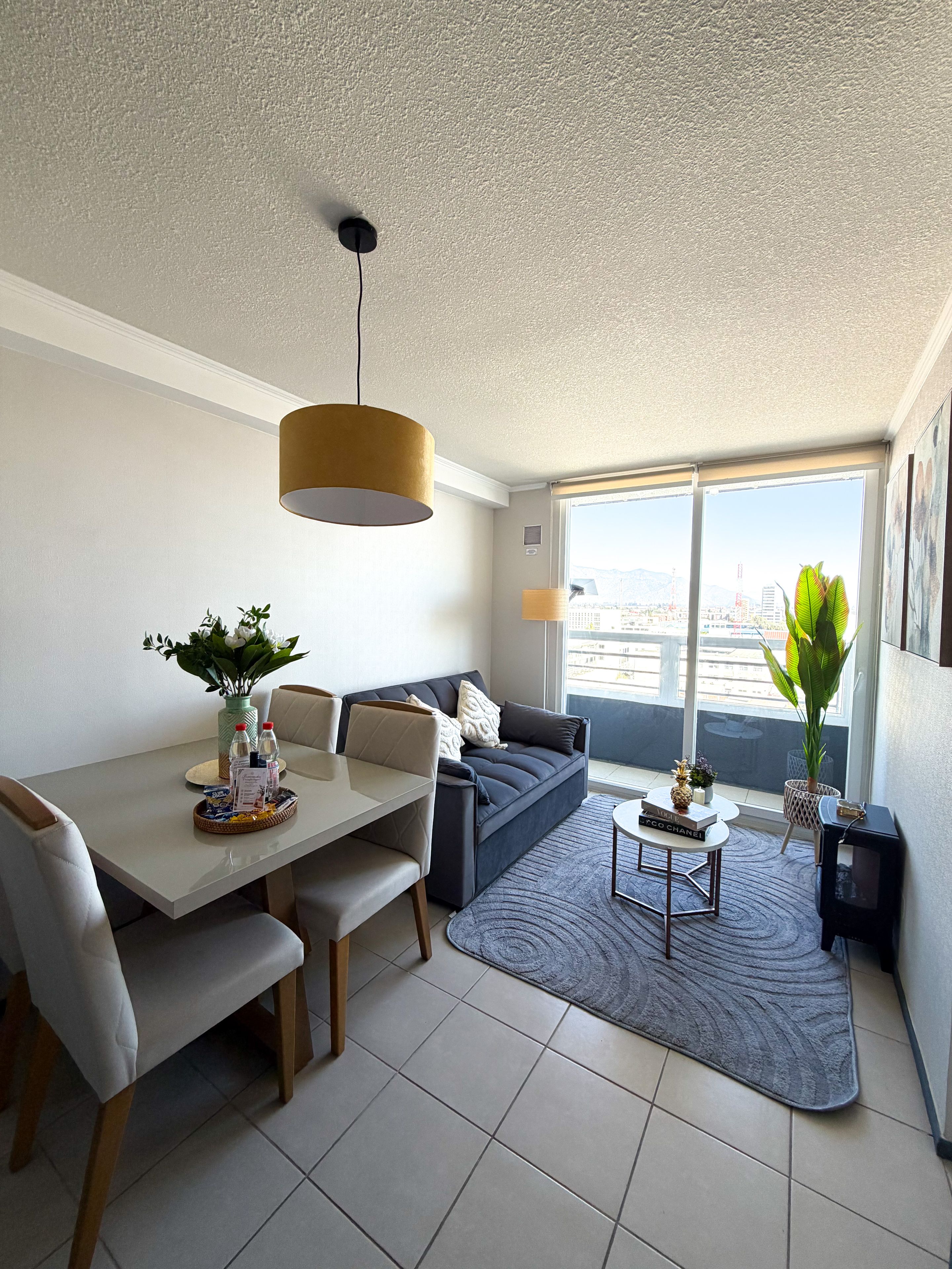 Un salon moderne comprenant un coin repas, un canapé, une table basse et une vue sur la ville.