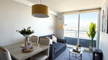 Un salon moderne comprenant un coin repas, un canapé, une table basse et une vue sur la ville.