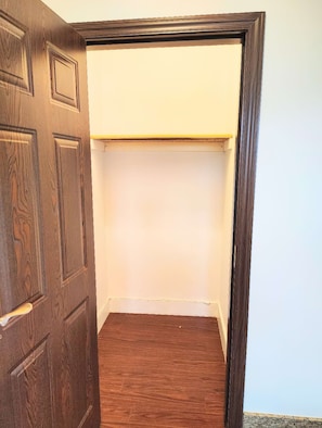 A room with a wooden door, a white wall, and a wooden floor. - Walk to Waimanalo Beach- 800sf 2 Bedroom 1 Bath Upstairs (Waimanalo)