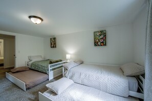 A bedroom with two beds, a bedside table with a lamp, and two floral paintings on the walls. - Great for Groups! Spacious Milroy Escape (Milroy)