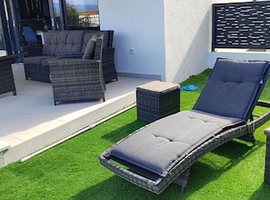 An outdoor seating area with wicker furniture and a small table. - Retro Luxury Swim & Stay Apartment (Murter-Kornati)