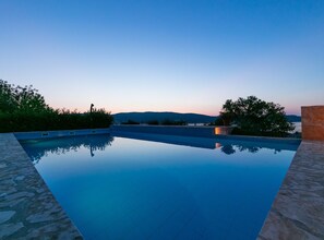 A clear swimming pool with a view of a mountain range in the distance. - Villas Linne (Vis)