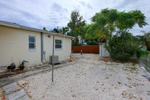 A residential property with a gravel driveway, a wooden fence, and a house with a satellite dish. - 2 Mi to Universal Orlando! Quiet Studio Suite (Orlando)