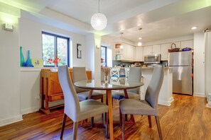 A modern kitchen with white cabinets, a stainless steel refrigerator, and a microwave.