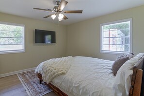 A bedroom with a bed, a ceiling fan, a mounted TV, and two windows with blinds. - 2 Mi to MSU Campus: Starkville 4BR Home (Starkville)