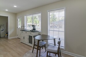 A kitchen with a dining table and chairs, a stove, and a window with blinds. - 2 Mi to MSU Campus: Starkville 4BR Home (Starkville)