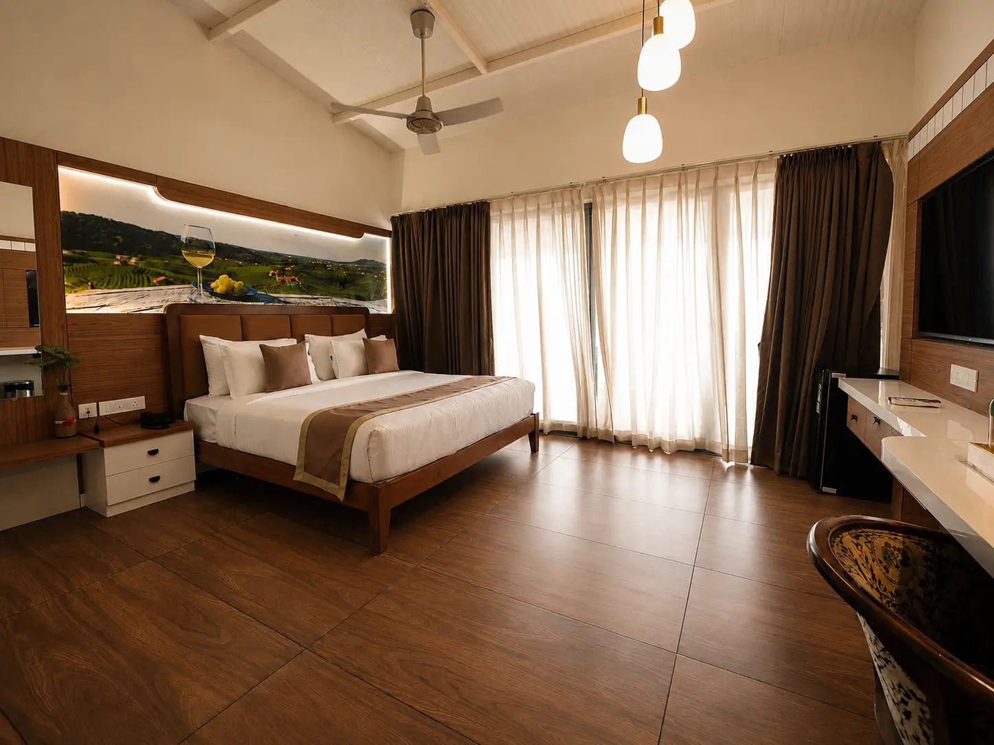 A hotel room with a bed, a desk, a television, and a large window with curtains.