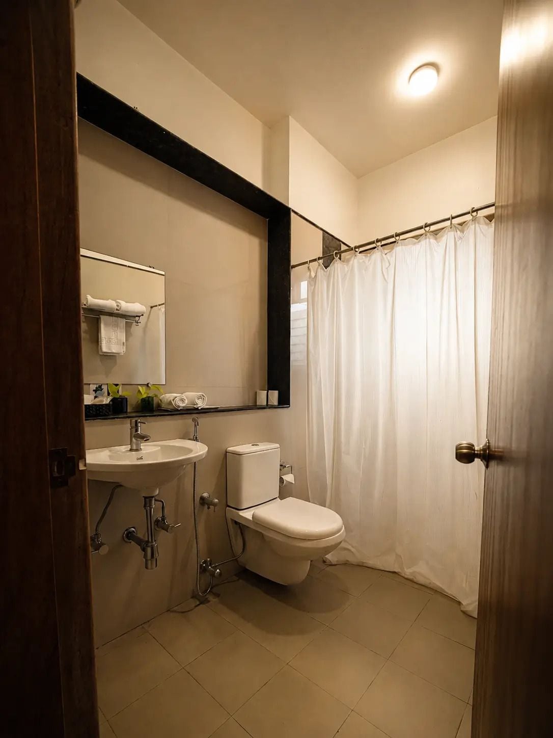 A bathroom with a sink, toilet, and shower curtain.