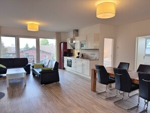 A modern apartment with a living room, dining area, and kitchen. - Three-Bedroom Vacation Apartment Near the Beach - Mein Glowe - 1st Floor, Right (Glowe)