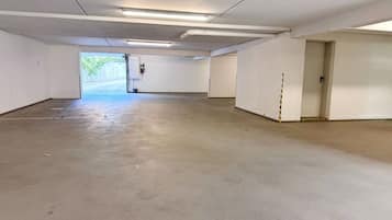 A spacious, empty parking garage with concrete floors and white walls.