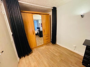 A room with a wooden wardrobe, a mirror, and a black dresser. - Comfortable & Stylish Property in a Great Location (Corrèze)