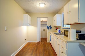 A kitchen with wooden flooring, white cabinets, a built-in oven, and a microwave. - 7 Mi to Mall of Georgia: Fire Pit & Yard (Buford)