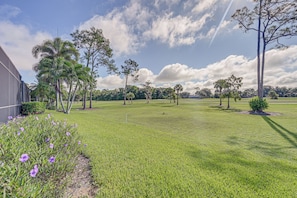 A grassy field with trees and a building on the left. - Tee Times + Poolside Vibes! Extended Naples Escape (Naples)