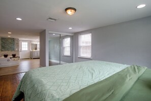 A bedroom with a bed, a bathroom with a mirror, and a hallway leading to another room. - 4 Mi to Bourbon St & Superdome! Spacious Home (New Orleans)