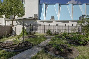 A garden with raised beds, a pathway, and a building with blue siding in the background. - 4 Mi to Bourbon St & Superdome! Spacious Home (New Orleans)