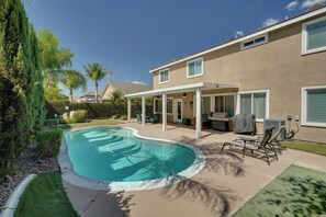 A residential property with a swimming pool, patio furniture, and a covered outdoor area. - Sun-Soaked Luxurious Home w/ Pool & Home Gym (Corona)
