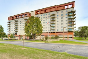 A multi-story residential building with balconies, a parking area, and a flagpole. - Grand Lake Golf Course Getaway: Stunning Views! (Afton)