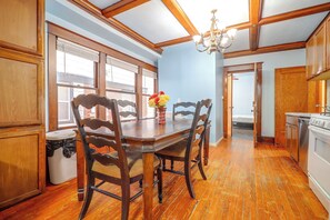 A dining room with a wooden table, chairs, and a chandelier. - Kansas City Rental Near Union Station & Hospitals (Kansas City)