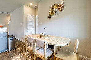 A dining area with a table, chairs, and a decorative wall piece. - Yard, Patio! Spacious Family Home By The Woodlands (Conroe)