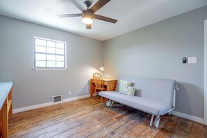 A room with a ceiling fan, a window, a sofa, a desk, and a chair. - 9 Mi to Six Flags! Wooded Retreat w/ Patio (San Antonio)
