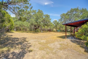 An outdoor area with a covered seating area and a fenced garden. - 9 Mi to Six Flags! Wooded Retreat w/ Patio (San Antonio)