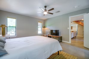 Ein Schlafzimmer mit einem Bett, einem Fernseher und einem Deckenventilator.