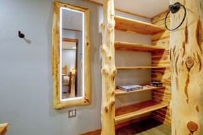 Una stanza con un'unità a scaffali in legno, uno specchio e un tavolino con giochi da tavolo.
