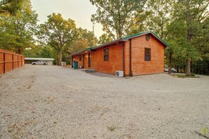 A wooden cabin with a gravel driveway, a covered porch, and a small front yard. - 1/2 Mi to Marina! Modern Bull Shoals Lake Cabin (Bull Shoals)