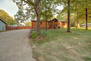 A wooden cabin with a porch, a gravel driveway, and a fenced yard. - 1/2 Mi to Marina! Modern Bull Shoals Lake Cabin (Bull Shoals)