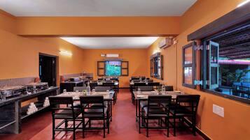 Un restaurant doté de plusieurs tables et chaises, d’un système de climatisation et d’une grande fenêtre offrant une belle vue.