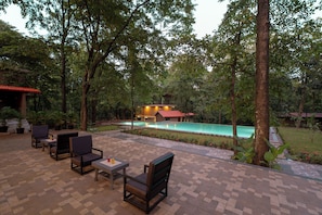 An outdoor patio with seating and a swimming pool.