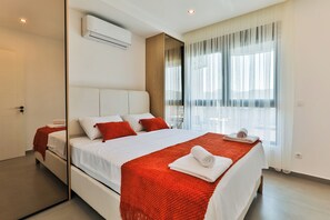 A modern hotel room with a large bed, a built-in wardrobe, and a large window with curtains. - One Bedroom Apartment with City View (Bar)