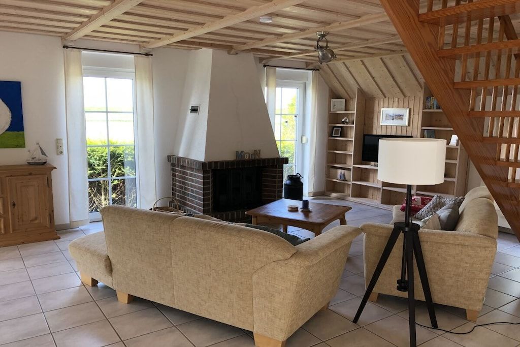 Un salon chaleureux avec une cheminée, un canapé, une table basse et une bibliothèque.