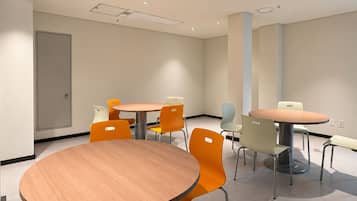 A conference room with round tables and chairs, a door, and a ceiling with recessed lighting.