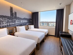 A hotel room with three beds, a cityscape mural, a large window with curtains, and a flat-screen TV. - Travelodge Gangnam Yeoksam Seoul (Seoul)
