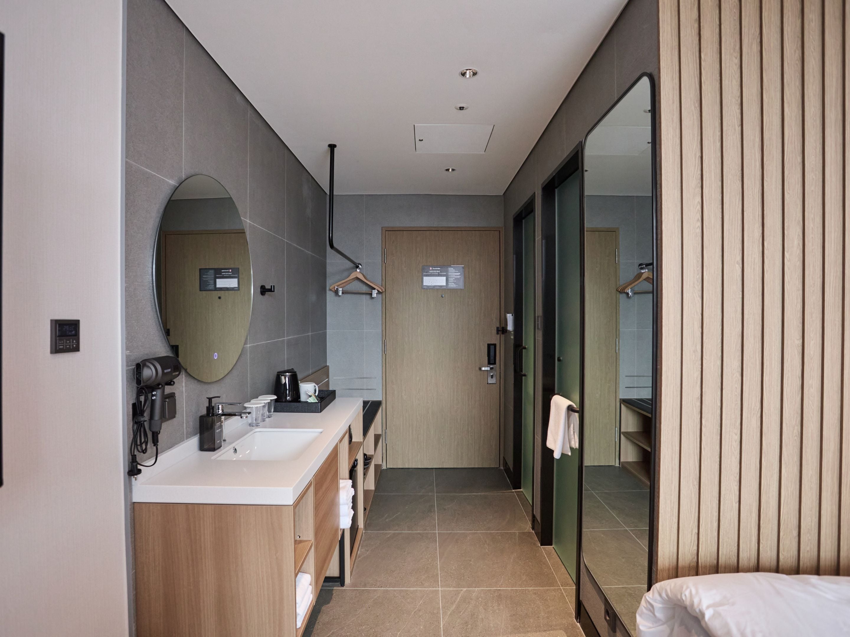 A modern bathroom with a dual sink vanity, a large mirror, and a walk-in shower.
